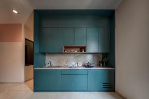 a kitchen with blue cabinets and a sink at Cove Oekude Residence in Jakarta