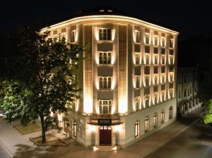 a large building with lights on it at night at The Crown Krakow Center - Handwritten Collection in Kraków