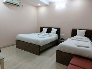 two beds in a hotel room with at Hotel Satyam in Jaigaon