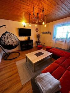 ein Wohnzimmer mit einem roten Sofa und einem Tisch in der Unterkunft Chalupa v Oblacích in Jindřichov