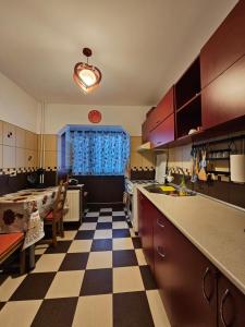a kitchen with a checkered floor and a dining room at Cosy apartment close to City Center with parking lot in Bucharest