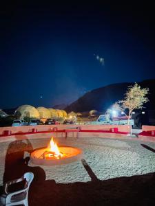 uma fogueira num parque de estacionamento à noite em Bilal luxury camp em Wadi Rum