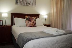1 dormitorio con 1 cama con almohada y 2 lámparas en Accommodation at Potch Guesthouse, en Potchefstroom