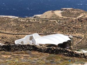 un coche blanco aparcado en el costado de una colina en Villa Aegean Lighthouse, en Fanari