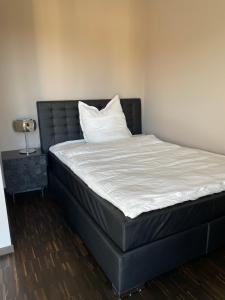 een bed met een zwart hoofdeinde en een wit kussen bij Luxury/Urban Penthouse in Dresden