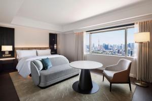 a hotel room with a bed and a table and chair at The Westin Tokyo in Tokyo