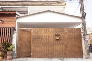 una puerta de madera delante de una casa en Ratchada Retreat Villa 2, en Bangkok