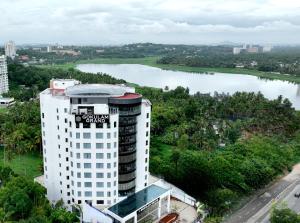 a tall white building with a river in the background at Gokulam Grand Trivandrum in Trivandrum