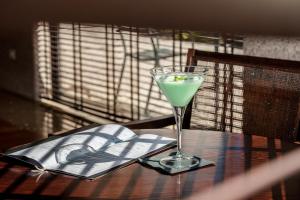 a drink in a glass on a table with a book at Hotel Dom Goncalo & Spa in Fátima