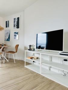 una sala de estar blanca con TV en un escritorio blanco en Apartment Blue Monis with Amazing Views, en Icod de los Vinos