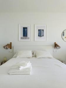 Una cama blanca con dos toallas blancas. en Apartment Blue Monis with Amazing Views, en Icod de los Vinos