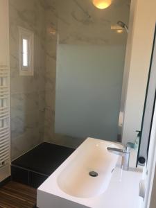 ein Badezimmer mit einem weißen Waschbecken und einer Dusche in der Unterkunft Ti Maen in Frehel