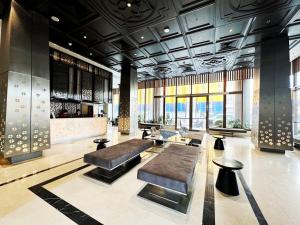 eine Lobby mit Bänken und eine Bar in einem Gebäude in der Unterkunft Ayathorn Bangkok in Bangkok + 37 Fotos
