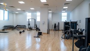 a gym with treadmills and exercise equipment on a wooden floor at Cowboy Charm 1BR Apartment on Yas Island in Abu Dhabi