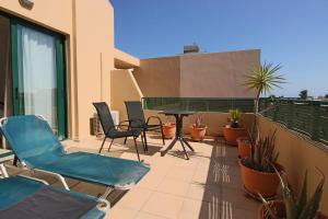 eine Terrasse mit Stühlen und einem Tisch auf dem Balkon in der Unterkunft Villa Oscania in Georgioupoli