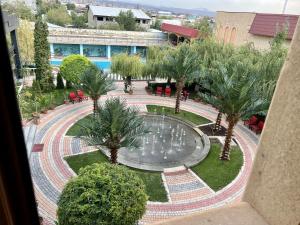 エレバンにあるArmenian Royal Palaceの噴水とヤシの木がある中庭の景色を望めます。