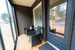 - werandę ze stołem i krzesłami obok drzwi w obiekcie Tahkokorva Studios by Hiekka Booking w mieście Kalajoki