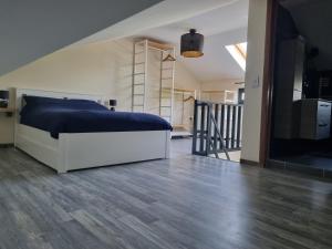 a bedroom with a large bed and a staircase at Studio Lillois in Bois le Duc