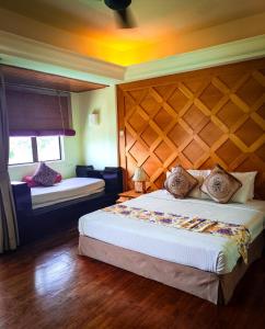 ein Schlafzimmer mit einem großen Bett und einem Kopfteil aus Holz in der Unterkunft Langkawi Lagoon Resort Seaview in Pantai Cenang