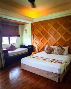 ein Schlafzimmer mit einem großen Bett und einem Kopfteil aus Holz in der Unterkunft Langkawi Lagoon Resort Seaview in Pantai Cenang + 43 Fotos