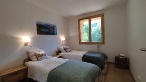 een kamer met 2 bedden en een raam bij Chalet Le Refuge in Vaujany
