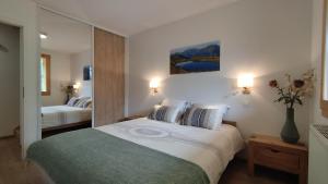 Pokój hotelowy z dużym łóżkiem i lustrem w obiekcie Chalet Le Refuge w mieście Vaujany