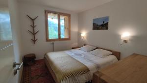 mała sypialnia z łóżkiem i oknem w obiekcie Chalet Le Refuge w mieście Vaujany +32 zdjęcia