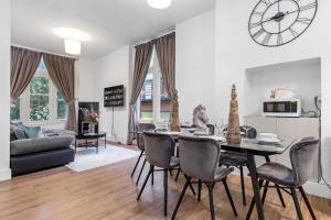 een eetkamer en een woonkamer met een tafel en stoelen bij Majestic 2 BR in Knightsbridge HydePark KB70 in Londen