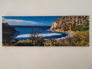 a painting of a beach next to the ocean at Domus Pannella - Endless Summer in Lacco Ameno