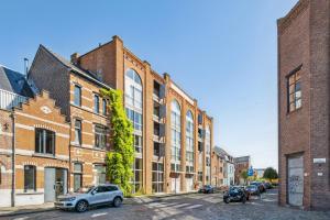 een stadsstraat met bakstenen gebouwen en auto's geparkeerd bij Industrial loft near the center of Ghent in Gent