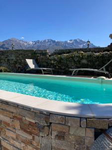 een zwembad in een stenen muur met een blauw zwembad bij Moulin « l’Anticu Fragnu » in Cateri