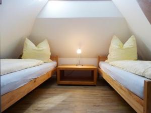 two beds in a small room with a table at Hus-Hiddensee-Eckhaus-A in Vitte