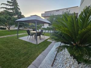 una mesa y sillas bajo una sombrilla en un jardín en FeWo Mira, en Vodice