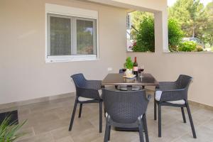 a table and chairs in a patio with a window at Apartments & Rooms Darrer in Poreč