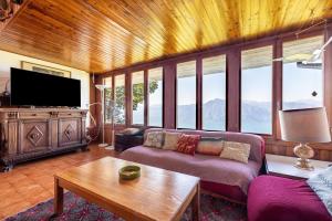 uma sala de estar com um sofá e uma televisão em Villa Franca San Zeno em San Zeno di Montagna