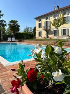 um vaso cheio de flores ao lado de uma piscina em CASCINA BELLAVISTA - Luxury Country Villa + Pool 