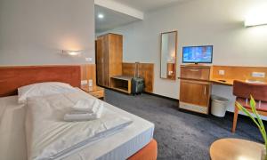 a hospital room with a bed and a tv at Hotel & Apart4you in Dorfen