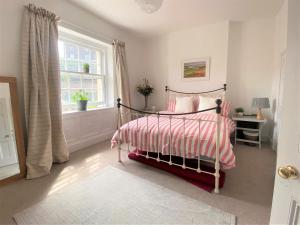 a bedroom with a bed with a pink and white blanket at Bohemian Family Home with Gorgeous Garden in Bristol