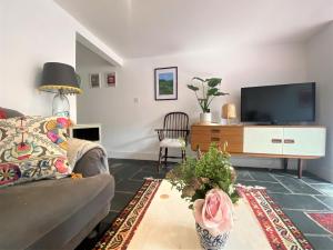 a living room with a couch and a tv at Bohemian Family Home with Gorgeous Garden in Bristol