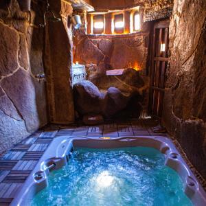 a jacuzzi tub in a cave with a stone wall at Casa Rural Therma Agreste in Bermellar