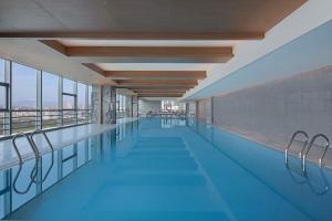 a large swimming pool with blue water in a building at Shantou Marriott Hotel in Shantou