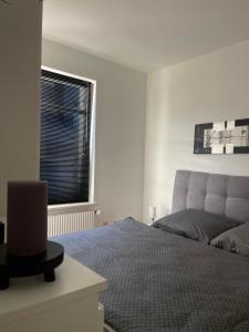 a white bedroom with a bed and a window at Gemütliche, helle Wohnung in Paderborn in Paderborn