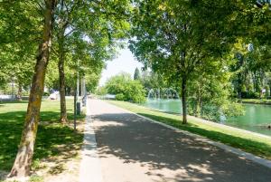 un camino en un parque junto a un río en Travel Homes - L'Alsacien, près de la ville, en Mulhouse