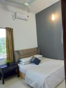1 dormitorio con 2 camas y ventana en Belebar Homestay Taman Negara Pahang Malaysia, en Kuala Tahan