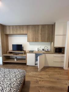 uma cozinha com armários brancos e uma cama num quarto em Apartmán Castle Bojnice em Bojnice