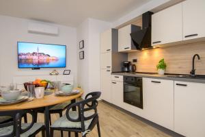 a kitchen with a wooden table and a dining room at Apartments & Rooms Darrer in Poreč