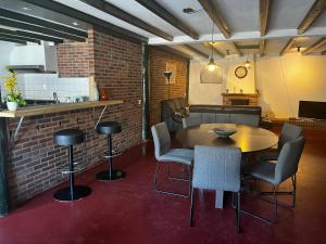 ディーフェルにあるFamiliehuisのテーブルと椅子、キッチンが備わる客室です。