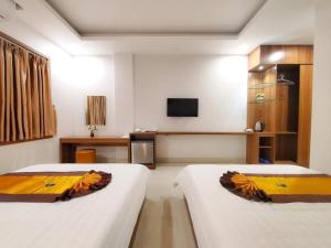 a hotel room with two beds and a television at Tuấn Linh Hotel in Ha Long