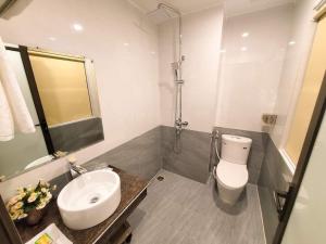 a bathroom with a white toilet and a sink at Tuấn Linh Hotel in Ha Long