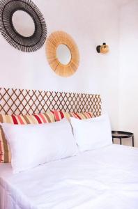 sypialnia z białym łóżkiem z 2 lustrami na ścianie w obiekcie Casa Veronica 3 , 1 dormitorio w mieście Las Galletas